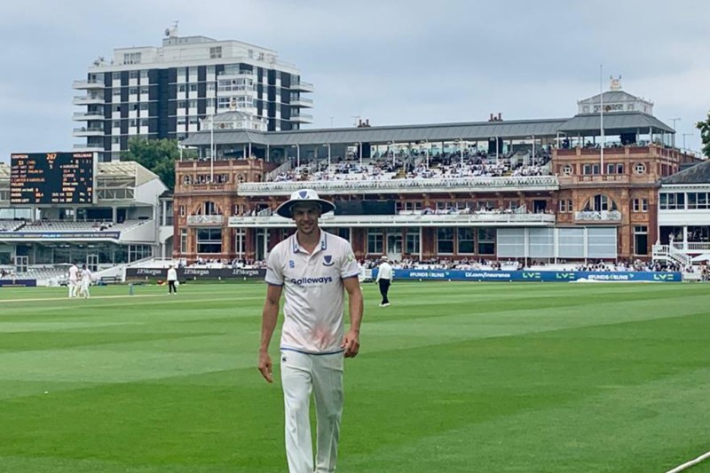 Bradley Currie on Lords Cricket ground in his Sussex kit with the famous pavilion in the background