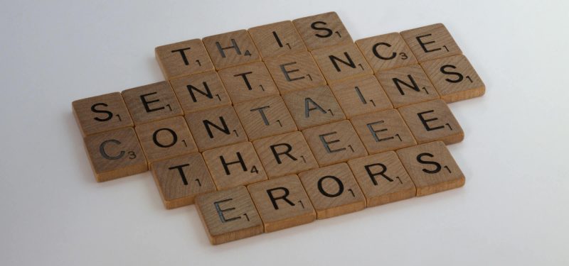 Scrabble letters arranged into the sentence: This Sentence Contains Threee Erors