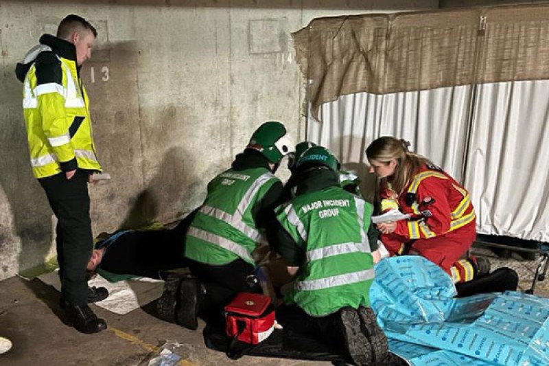 Paramedic students gathered on the floor of the car park with directing staff treating a casualty