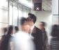 A blurred, moving conference crowd with stationary man in suit